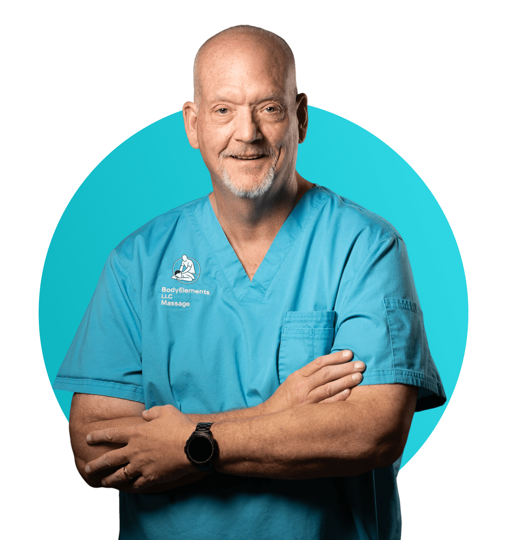 Smiling male doctor in blue scrubs with arms crossed.