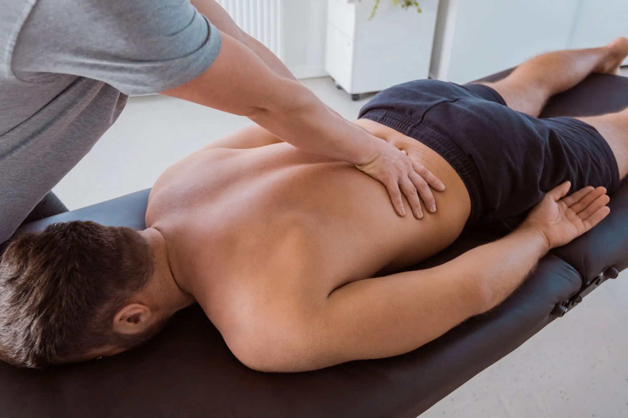 Person receiving a back massage on a table.